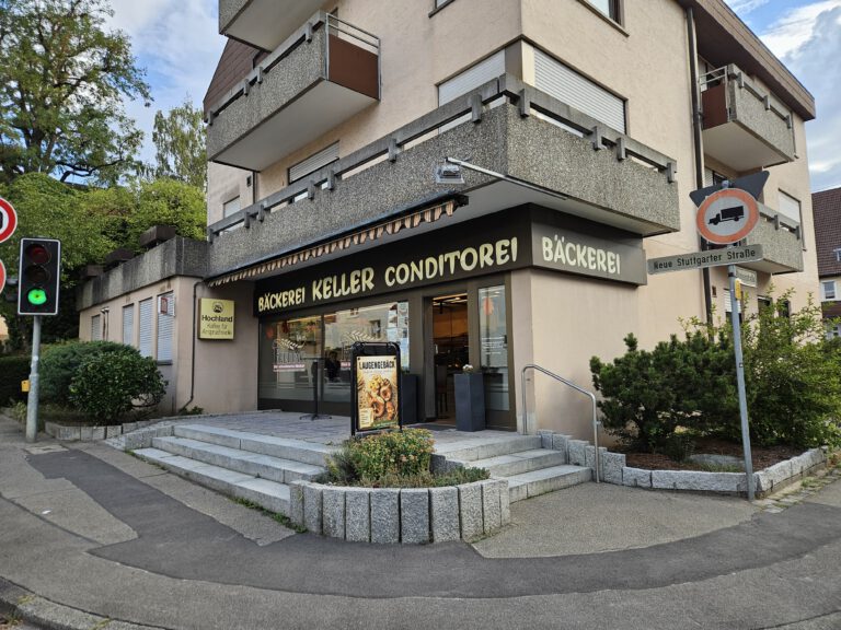 Backstube und Backstubenverkauf in Magstadt mit Ladenbeschriftung, Eingang und Blumen vor der Treppe
