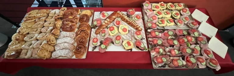 Firmenbuffet mit belegten Brötchen und süßem Gebäck